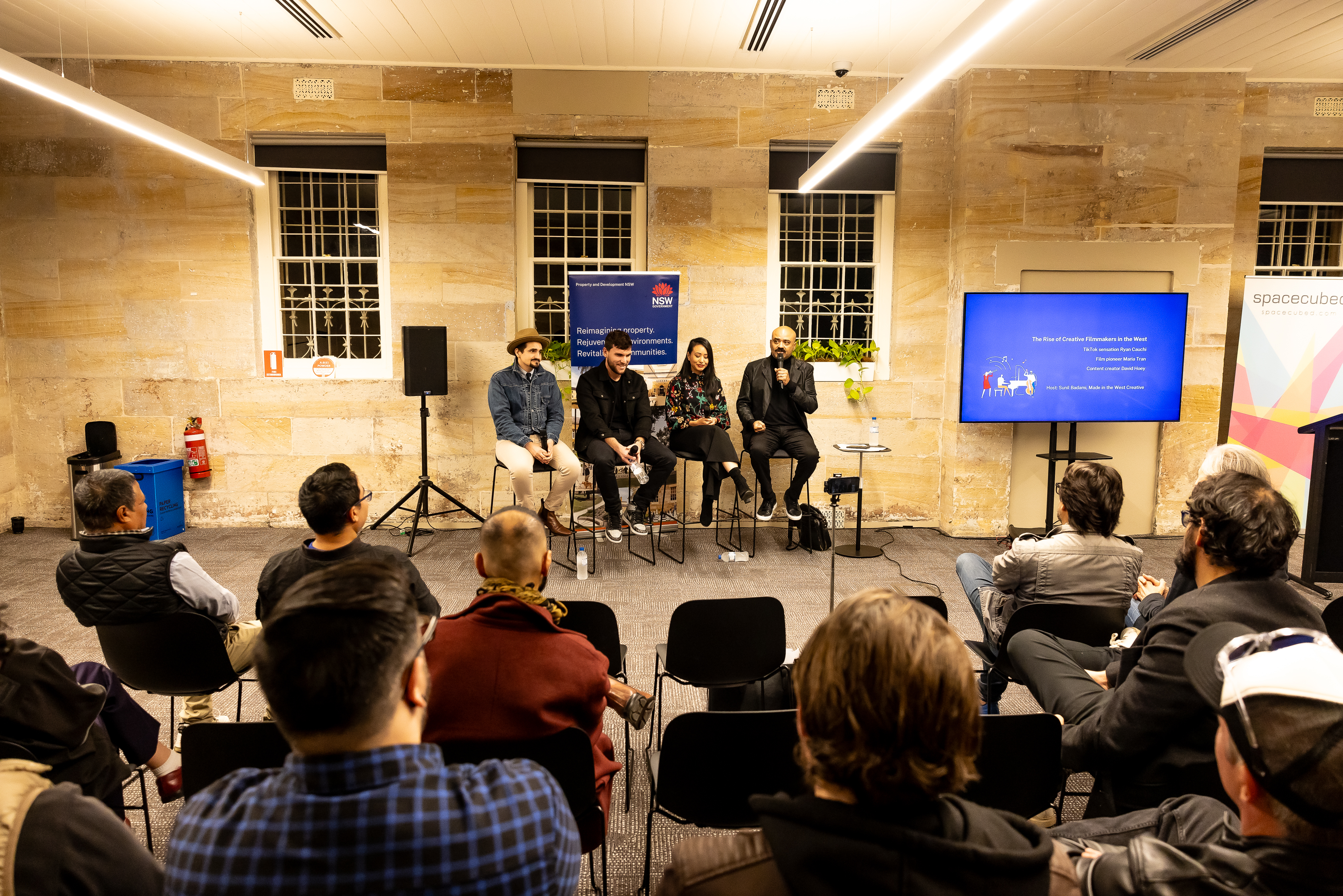 Four artists sitting on a panel with microphones
